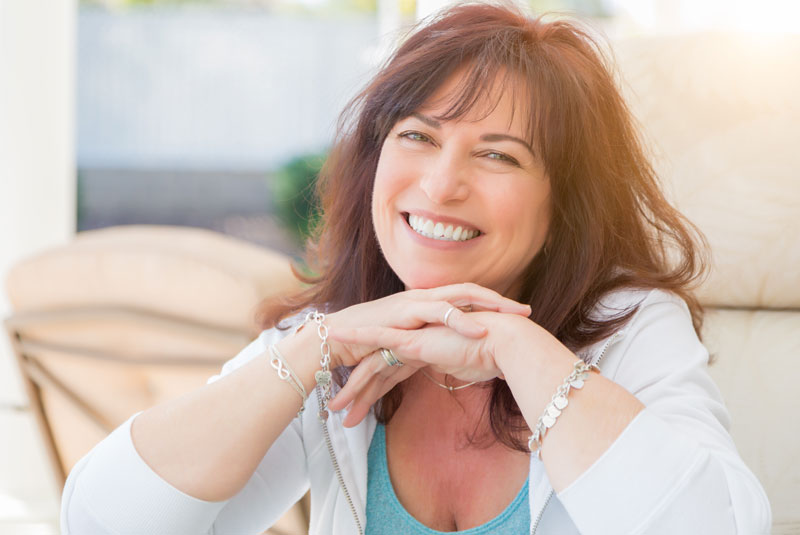 a patient smiling after her all on 4 dental implant procedure